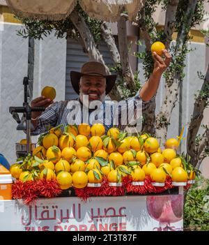 Agadir, Marokko--26. Mai 2023. Ein Händler, der einen frisch gepressten Orangensaft im Souk trägt Stockfoto