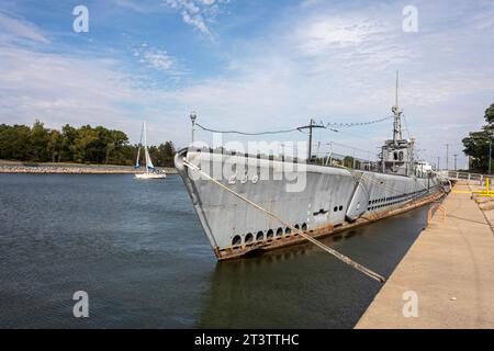 Muskegon, Michigan – Ein Segelboot passiert die USS Silversides, ein U-Boot der Gato-Klasse aus dem Zweiten Weltkrieg, das am USS Silversides Submarine Museum angedockt ist. Stockfoto