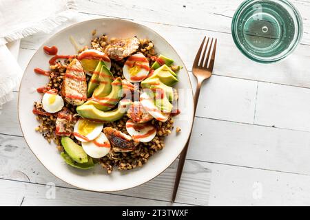 Eine gesunde Proteinschale mit Hühnchen und gekochtem Ei auf einem Bett mit Quinoa. Stockfoto