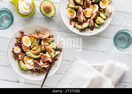 Gesunde, hausgemachte Proteinschüsseln mit Eiern, Huhn und Avocado. Stockfoto