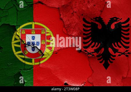 Flaggen von Portugal und Albanien auf gerissene Wand gemalt Stockfoto