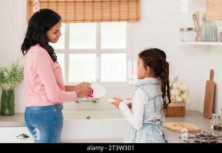 Mutter Tochter wäscht Geschirr Stockfoto