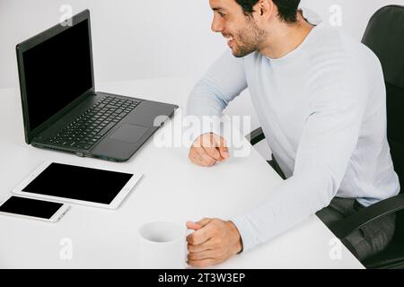 Smiley Mann mit technologischen Geräten Kaffeetasse Stockfoto