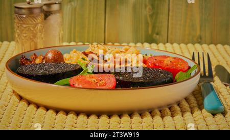 Warmes Frühstück mit Schwarzpudding und Eiern. Stockfoto