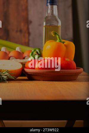 Gemischtes Gemüse mit etwas Olivenöl und frischen Eiern auf einem Küchentisch. Stockfoto