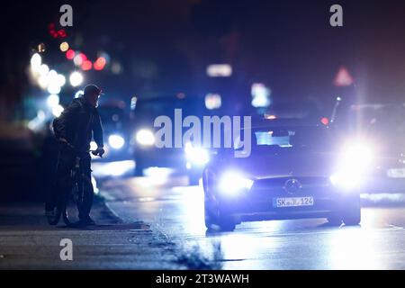 Leipzig, Deutschland. Oktober 2023. Ein Radfahrer wartet an einer stark befahrenen Hauptstraße auf die Möglichkeit, zu überqueren. Quelle: Jan Woitas/dpa/Alamy Live News Stockfoto