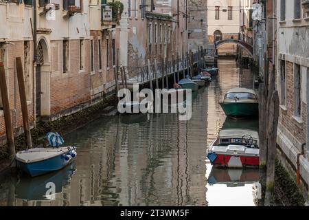 Kleine Boote parkten in einem typischen Kanal im Herzen von Venedig, Italien Stockfoto