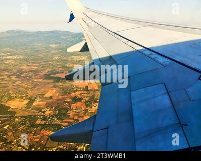 Blick über den Flügel eines Passagierflugzeugs auf den Feldern der Baleareninsel Mallorca im Mittelmeer Stockfoto