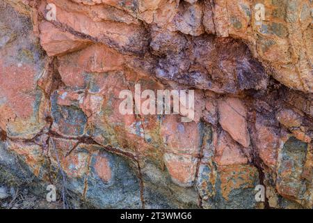 Farbenfrohe vulkanische Gesteinsstrukturen und Mineralien eines Berges in Rodalquilar, Almeria, Spanien. Ignimbrit mit Jarosit und Goethit Stockfoto