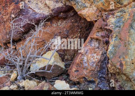 Farbenfrohe vulkanische Gesteinsstrukturen und Mineralien eines Berges in Rodalquilar, Almeria, Spanien. Ignimbrit mit Jarosit und Goethit Stockfoto