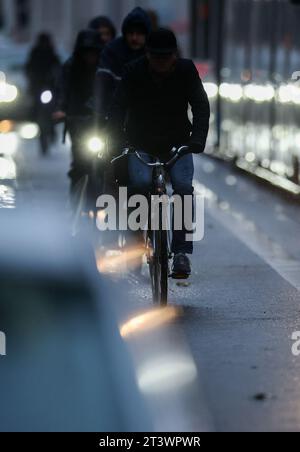 Leipzig, Deutschland. Oktober 2023. Ein Radfahrer ohne Lichter fährt in der morgendlichen Hauptverkehrszeit im Regen. Quelle: Jan Woitas/dpa/Alamy Live News Stockfoto