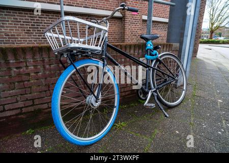 ZWOLLE, NIEDERLANDE - 14. MÄRZ 2021: Modernes Stadtfahrrad mit blauem Vorderreifen und Transportkorb Stockfoto