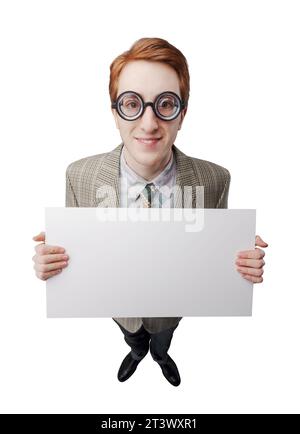 Lustiger Nerd mit dicker Brille, er hält ein leeres Schild und lächelt Stockfoto