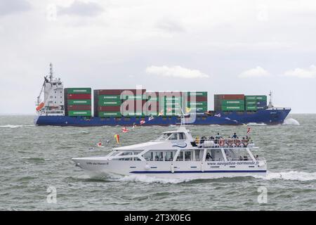 Le Havre, Frankreich - das Passagierschiff VILLEDUHAVRE II kreuzt vor einem Containerschiff im Ärmelkanal. Stockfoto