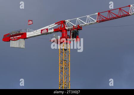 Le Havre, Frankreich - Roter weiß-gelber Turmkran Potain MDT 389 L16 am stürmischen Himmel. Stockfoto