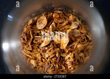 Gebratene Zwiebeln (Bawang Goreng) in einem kleinen Glas oder einer Schüssel. Bawang Goreng sind in Scheiben geschnittene ​​red Zwiebeln, die goldbraun und knusprig gebraten werden. Indonesien Stockfoto