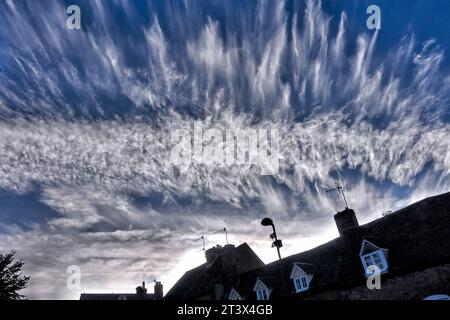 Cirrus Wolken, auch bekannt als Stutenschwänze, mit Häusern darunter. England Großbritannien Stockfoto