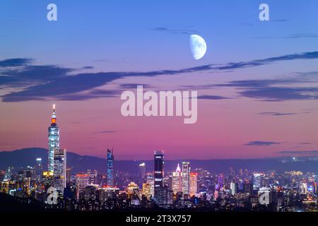 Nachts leuchten die bunten Lichter allmählich auf. Der Mond ist auch am Himmel. Orange-rote Nachtansicht auf die Stadt nach Sonnenuntergang im Herbst. Taipeh, Taiwa Stockfoto