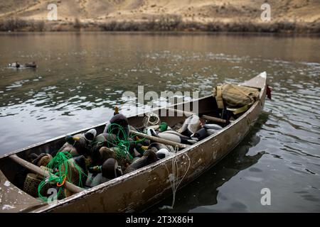 Kanu auf dem Fluss mit Entenködern und Jagdvorräten Stockfoto