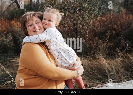 4-jähriges Mädchen umarmt Oma an einem Herbsttag Stockfoto