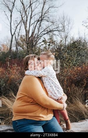 4-jähriges Mädchen umarmt Oma an einem Herbsttag Stockfoto