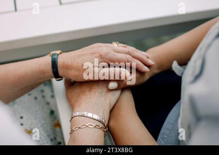 Mittelteil von Seniorenmann und Handpflegerin im Altersheim Stockfoto