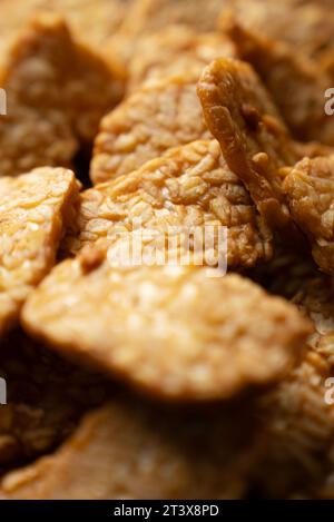 Das traditionelle indonesische Gericht „Tempeh goreng“ ist ein traditionelles indonesisches Essen, das aus fermentierten Sojabohnen hergestellt wird. Ansicht von oben nach unten (Nahaufnahme) Stockfoto