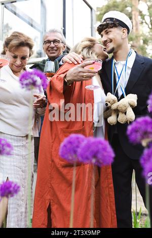 Lächelnde Männer und Frauen genießen die Sommerparty im Hinterhof Stockfoto