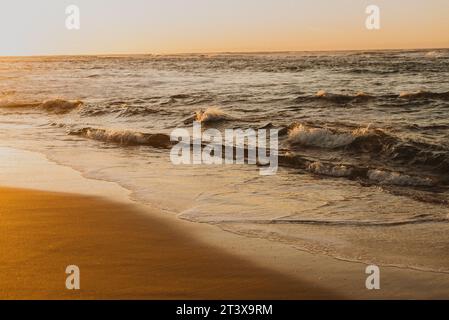 Meereswellen brechen beim Sonnenaufgang an der Küste Stockfoto