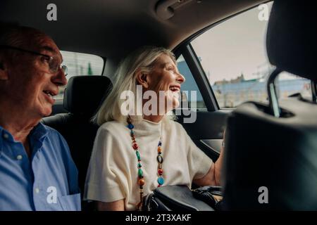Fröhliches Seniorenpaar genießt eine Taxifahrt in der Stadt Stockfoto