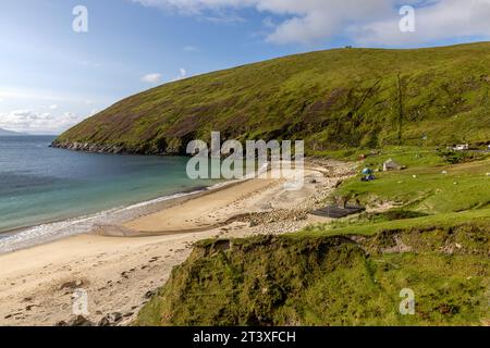 Keem Beach in Irland ist ein weißer Sandstrand mit türkisfarbenem Wasser, eingebettet zwischen hoch aufragenden Klippen auf Achill Island. Stockfoto