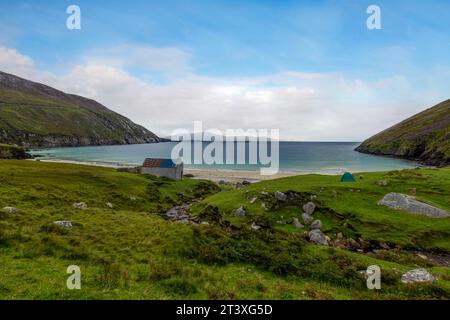 Keem Beach in Irland ist ein weißer Sandstrand mit türkisfarbenem Wasser, eingebettet zwischen hoch aufragenden Klippen auf Achill Island. Stockfoto