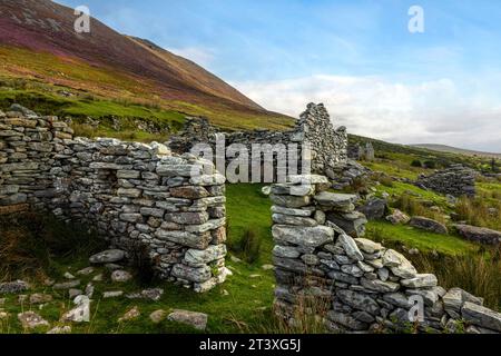 Slievemore Deserted Village ist eine geschützte archäologische Stätte und ein beliebtes Touristenziel, das Besuchern einen Einblick in das traditionelle irische Dorf bietet Stockfoto