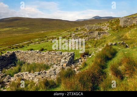 Slievemore Deserted Village ist eine geschützte archäologische Stätte und ein beliebtes Touristenziel, das Besuchern einen Einblick in das traditionelle irische Dorf bietet Stockfoto