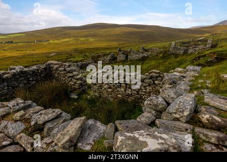 Slievemore Deserted Village ist eine geschützte archäologische Stätte und ein beliebtes Touristenziel, das Besuchern einen Einblick in das traditionelle irische Dorf bietet Stockfoto