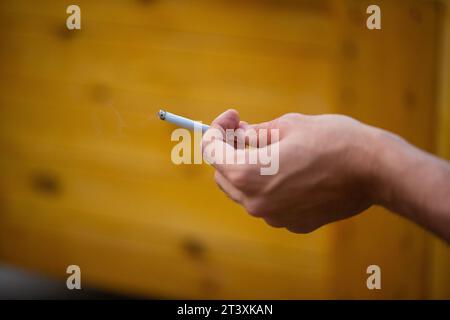 Berlin, Deutschland. Juli 2023. Ein Mann hält beim Rauchen eine brennende Zigarette in der Hand. Quelle: Fernando Gutierrez-Juarez/dpa/Alamy Live News Stockfoto