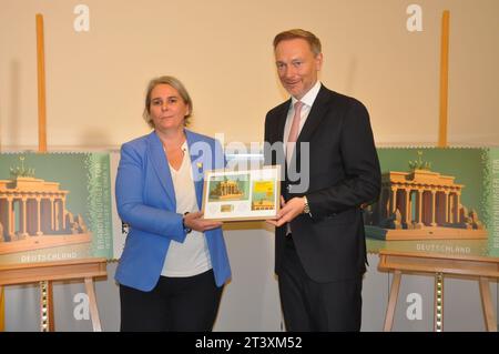 Berlin, Deutschland. Oktober 2023. Die deutsche Post gibt die erste Kryptomarke heraus, eine Kombination aus einer echten Briefmarke und einem digitalen Abdruck. Das Motiv ist das Brandenburger Tor, dargestellt durch künstliche Intelligenz. Nikola Hagleitner (links) von der Postleitung übergibt am 26. Oktober 2023 das erste Stück der limitierten Goldausgabe mit 100 Exemplaren an Bundesfinanzminister Christian Lindner in Berlin. Quelle: Zapotocky Ales/CTK Photo/Alamy Live News Stockfoto