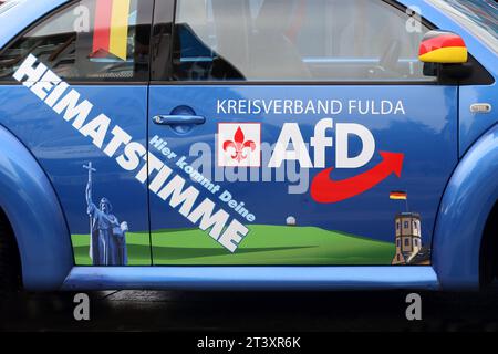 Blauer VW Käfer mit AfD-Wahlwerbung parkt vor einem Infostand der Partei AfD in der Fuldaer Innenstadt - Werbeaktion der Partei AfD zur Landtagswahl im Bundesland Hessen - Wahl zum 21. Hessischen Landtag - Fulda, Deutschland, DEU, Deutschland, DE 07.10.2023 - mehr als vier Millionen Hessen können bis zum 8. Oktober ihren neuen Landtag wählen. - Schriftzug: Hier kommt deine HEIMATSTIMME - KREISVERBAND FULDA - Logo: AFD - Außenspiegel und Fähnchen in den Deutschen Nationalfarben Schwarz - Rot - Gold - Abbildung: Turm mit Deutschlandflagge - Abbildung: Statue Bonifatius *** Blau VW Käfer mit AfD Stockfoto