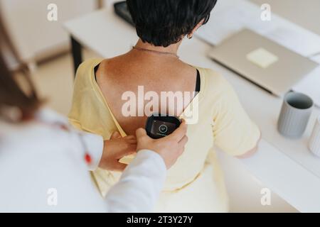 Der Arzt überprüft Blutdruck und Puls älterer Frauen mit medizinischen Geräten im Büro für umfassende Diagnose und Behandlung. Stockfoto