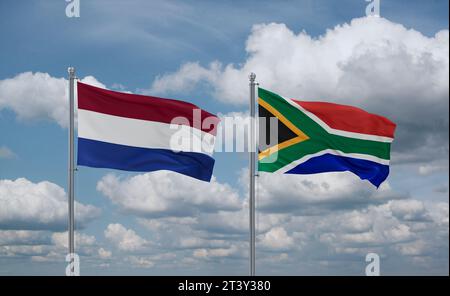 Die Flagge der Republik Südafrika und der Niederlande winken zusammen im Wind auf blauem bewölktem Himmel, zwei Länder-Beziehungskonzept Stockfoto