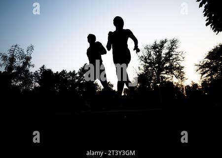 Evening Jogger: Aktives Paar Trainiert Gut Gebaute Körper Im Freien Stockfoto