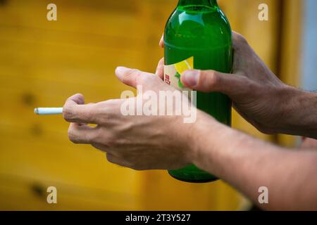 Berlin, Deutschland. Juli 2023. Ein Mann hält eine brennende Zigarette und eine Radler-Bierflasche in den Händen. Quelle: Fernando Gutierrez-Juarez/dpa/Alamy Live News Stockfoto