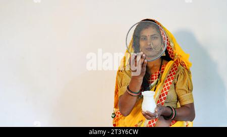 Indische schöne Frau Hand, die Karwa Chauth Sieb für die Karwa Chauth Feier hält, sind isoliert über weißem Hintergrund Stockfoto