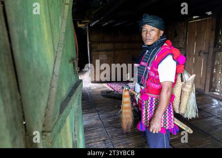 Mann aus dem Stamm der Adi in traditioneller adi-Kleidung posiert in seinem traditionellen Holzhaus in Assam im Nordosten Indiens Stockfoto