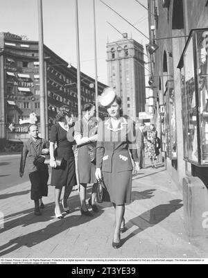 Frau in den 1940ern Schauspielerin Barbro Kollberg, die durch die geschäftige Stockholms Street schlendert. Sie trägt ein typisches Outfit aus den 1940er Jahren, einen eleganten Hut und eine Handtasche. Schweden 1943. Kristoffersson Ref. E54-2 Stockfoto