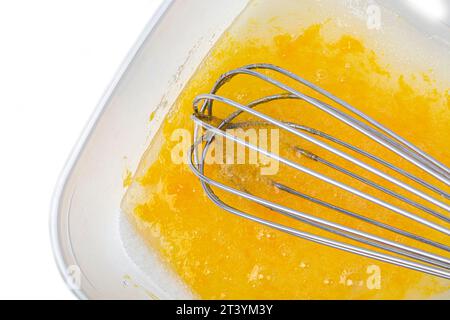 Zerbrochene Eier mit Zucker in einer Schüssel und Quirl Stockfoto
