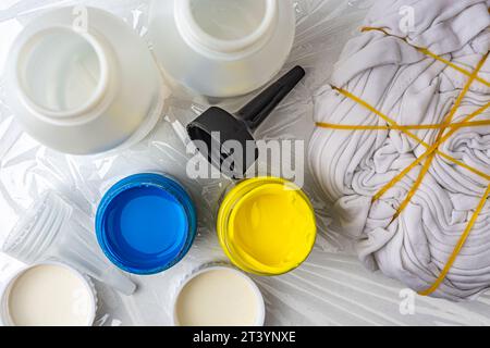 Gelbe, blaue Farbe und T-Shirt für Tie-Dye-Technik Stockfoto