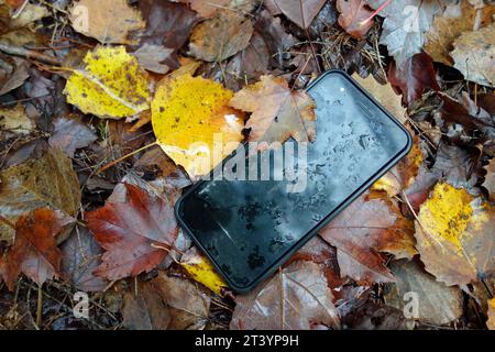 Ein Handy verloren im Wald auf dem Boden Stockfoto