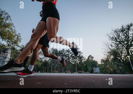 Sportliche Paare trainieren gemeinsam im Park bei Sonnenuntergang. Stockfoto