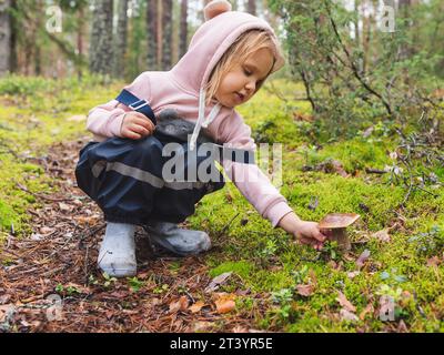Ein Mädchen im Grundalter fand beim Camping in einem Wald den Pilz Boletus edulis (cep oder Penny Brötchen) Stockfoto